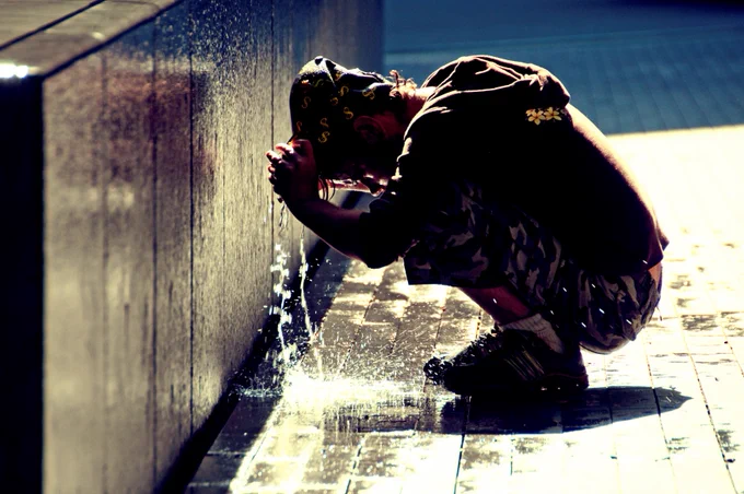 Londoner escapes extreme heat in water and shade. Credit: Christian Juilliard/ Climate Visuals