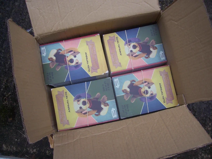 A cardboard box filled with bundles of Patchwuff postcards. 