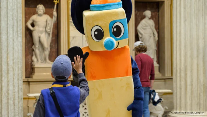 Ein Kind gibt einem Maskottchen ein High-Five. 