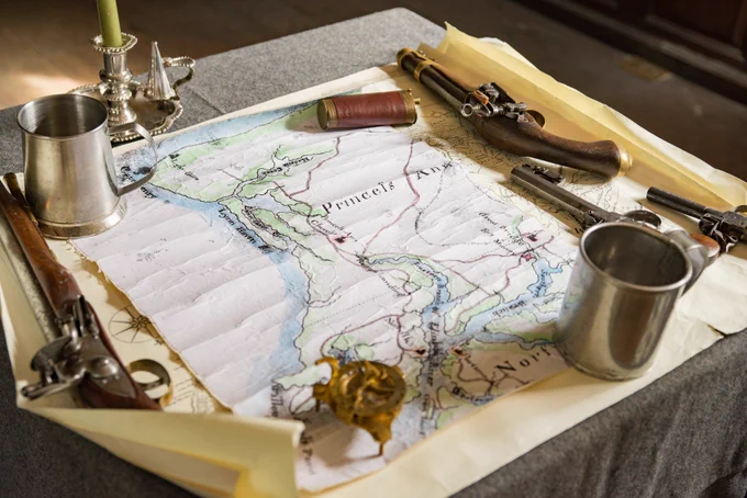 Gun Cups and Candles on a Table with a Map