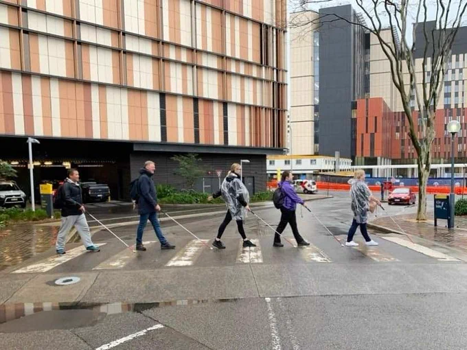 Orientation and mobility students crossing a pedestrian crossing with canes 