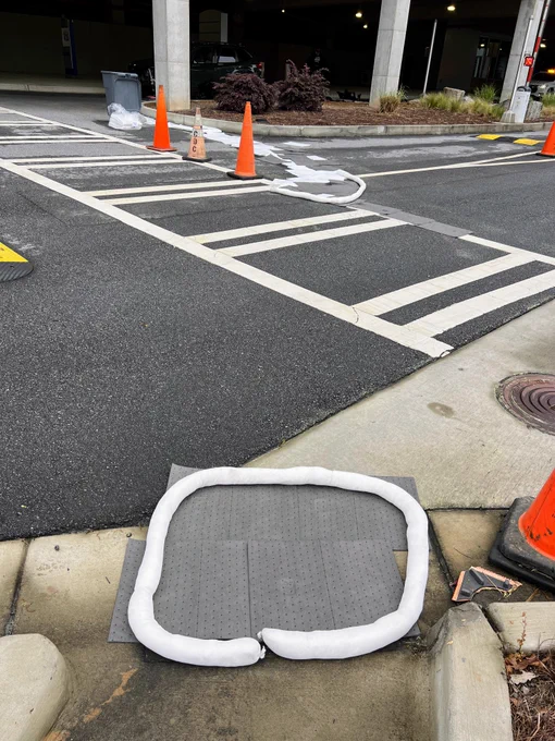 Absorbent material used to clean up a spill near a cross walk and culvert