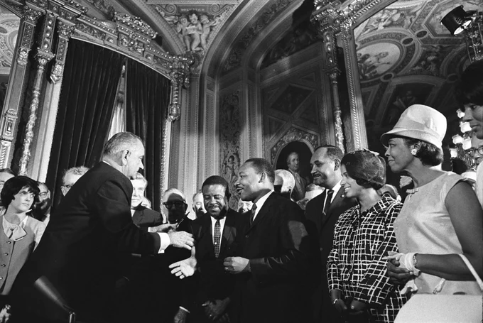 President Lyndon B. Johnson shakes hands with Martin Luther King Jr. after Johnson signed the federal Voting Rights Act into law.