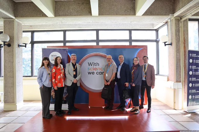 Group of seven people standing in front of a banner reading "With science we can" at the CGIAR Science Week event.