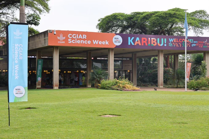Entrance to CGIAR Science Week event with welcoming banners in multiple languages (English, Swahili, Amharic) displayed above walkway, surrounded by a lush, green lawn.