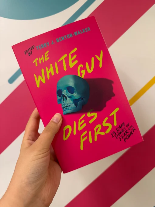 Someone holding up a copy of The White Guy Dies First edited by Terry J. Benton-Walker in front of a wall with pink, yellow, and teal stripes painted on it.