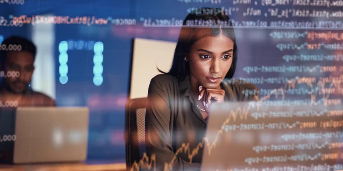 Pictorial representation of a BadSuccessor attack. A person analyzing data on a computer screen in a busy office environment, with digital graphs and code overlaying the image.