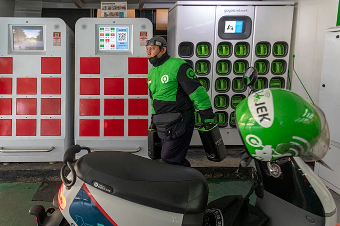 A driver of an electric taxi service exchanges his lithium-ion battery at a swapping station in Jakarta, Indonesia. Credit: Aji Styawan/Climate Visuals