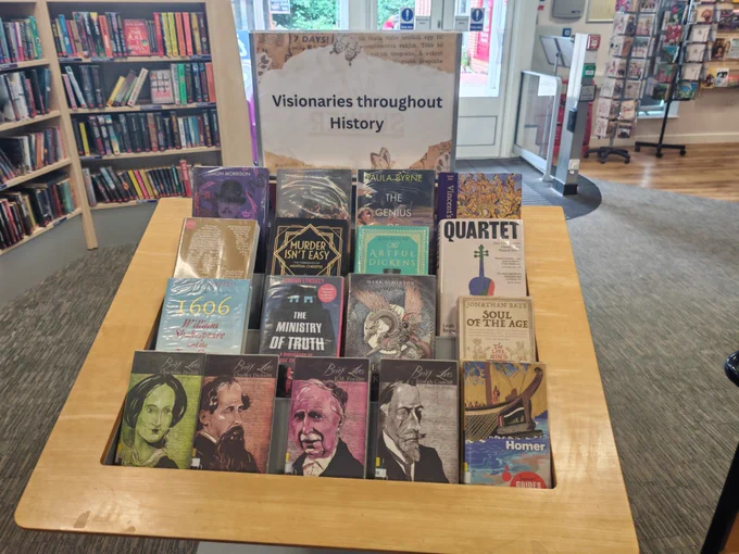 Book display containing books about famous authors, composers, and artists. Above the display, a poster reads "Visionaries throughout History".