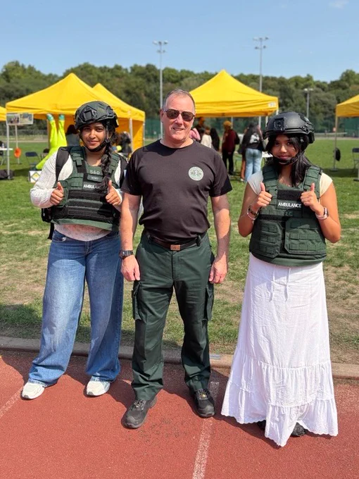 Two people trying on specialist ambulance kit. 