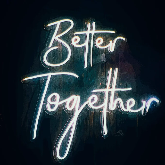 Neon sign reading 'Better Together' glowing in white and blue against a dark background.