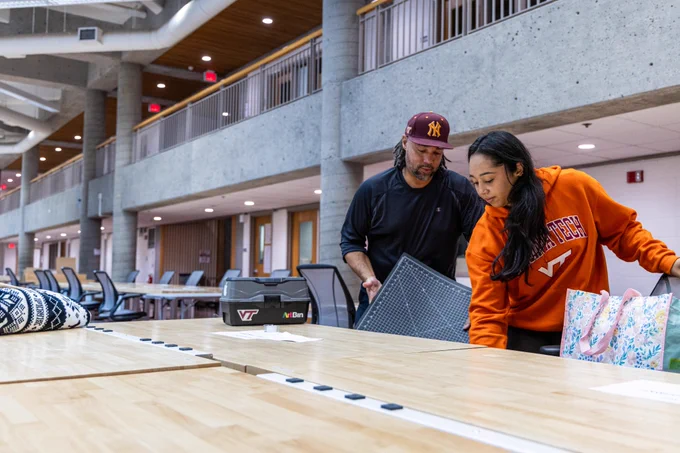 Two people putting materials away at new desk in Burchard Hall.