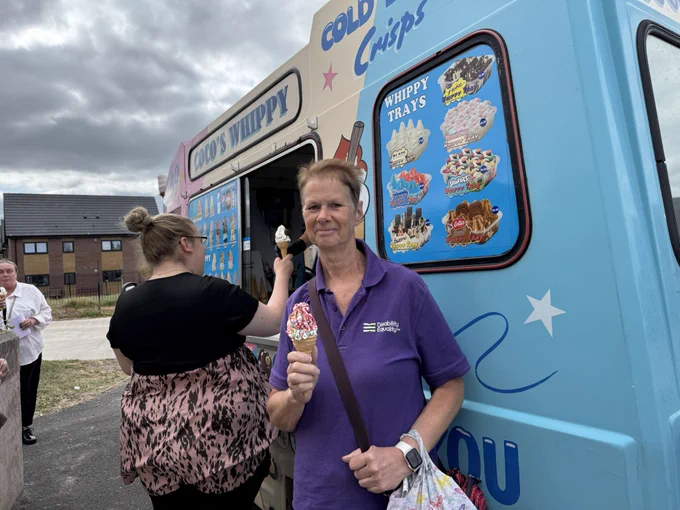 Women stood in front of ice cream van with ice cream in hand