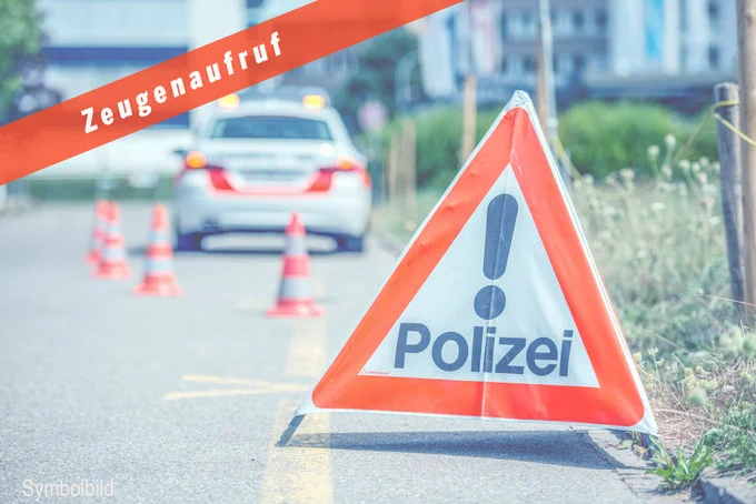 Polizei-Faltsignal auf der Strasse. Im Hintergrund steht ein Polizeiauto.