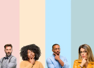 Four individuals are standing side by side against a backdrop of pastel-coloured vertical stripes. Each person has a thoughtful expression, with some resting their chin on their hand.