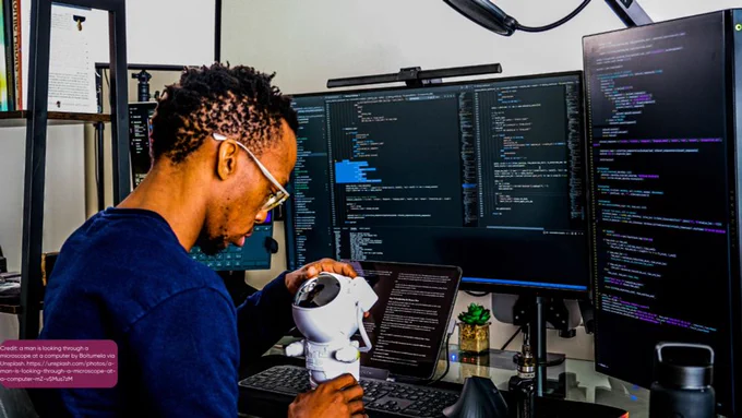 Man sting at computer while working on a robot
