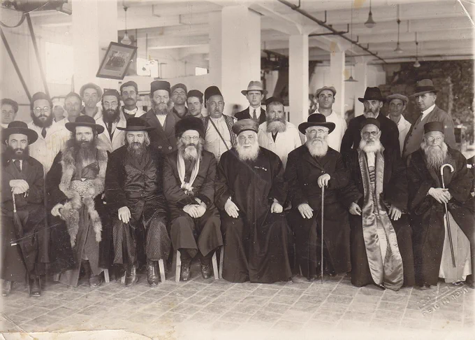 1921 visit of the rabbis to the Haifa power plant. 

Right to Left: Rabbi Ben-Ṣiyon Aḇraham Qoʾenqa, Rabbi Aḇraham Abuḥaṣira, Rabbi Barukh Marqos, Sepharadi Chief Rabbi Yaʿaqoḇ Meʾir, Ashkenazi Chief Rabbi Aḇraham Yitzḥaq haKohen Qooq, Rabbi Ṣeḇi Pesaḥ Feranq, Rabbi Shemuʾel Aharon Shazuri (Weber), Rabbi Yehoshuʿa Qaniʾel.