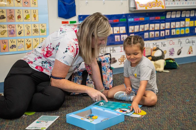 Teacher and student play an educational game together