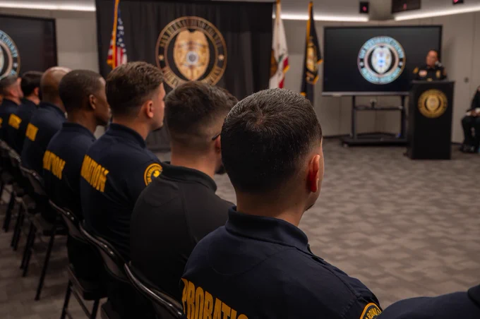A speaker addressing a group of probation officers during a graduation ceremony.