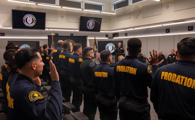 Officers raising their right hands as they take their oath during a swearing-in ceremony.