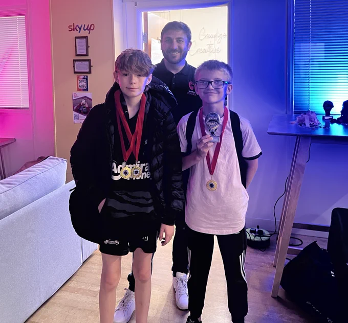 Two young people stood on front of an adult.