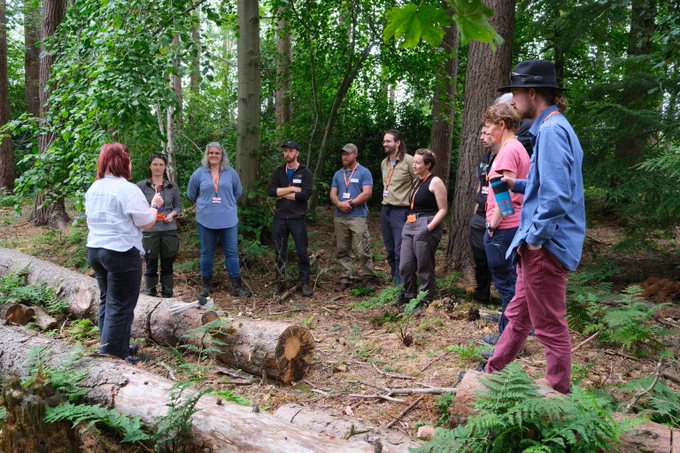 Group gathered round fallen log. 