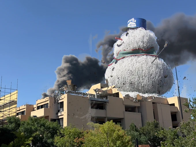 Photoshopped image of a massive tumbleweed snowman behind the humanities building with black smoke in the background.