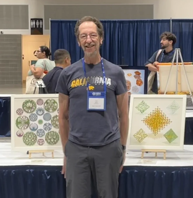 Dan in front of his two square art pieces at MathFest