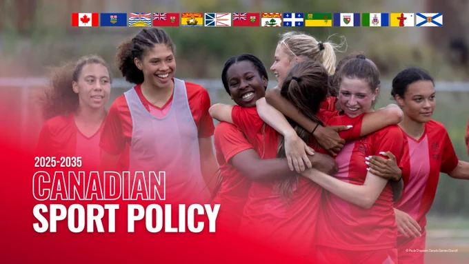 A group of young women in red sports uniforms smiling and hugging on a soccer field. A row of federal, provincial and territorial flags appear at the top. The text on the image reads: “2025–2035 Canadian Sport Policy.”