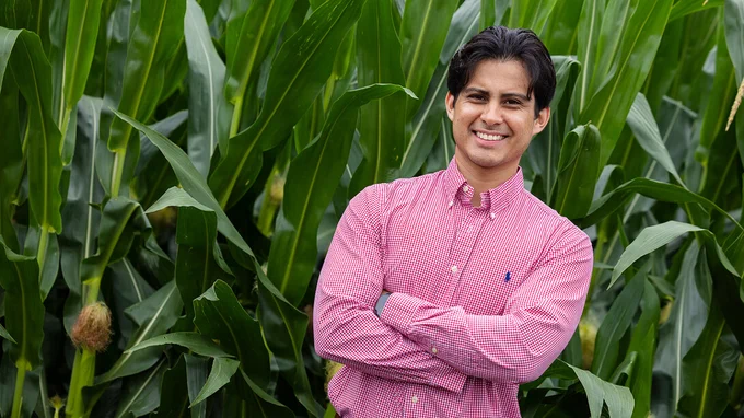 Vladimir Torres-Rodriguez, research assistant professor in agronomy and horticulture, stands with his arms crossed in front of corn plants. (Liz McCue/University Communication and Marketing)