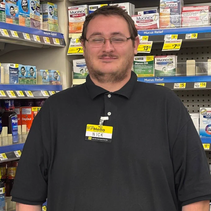 Employee smiling in store aisle. 