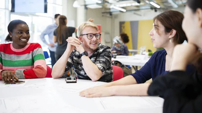 Four people sat around a table talking