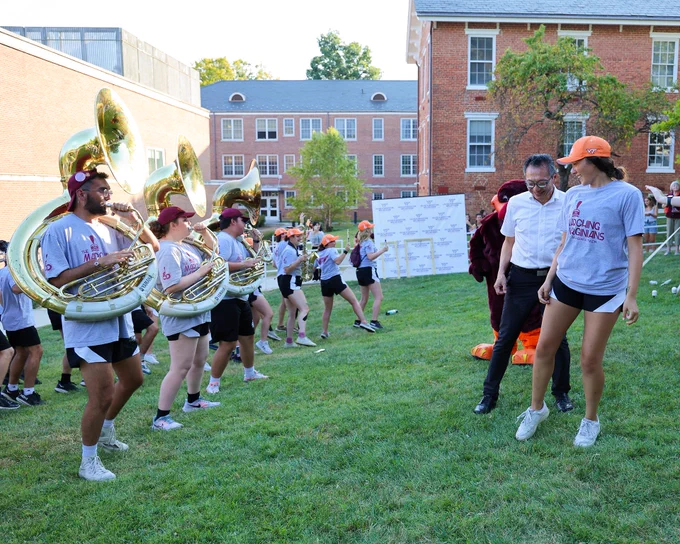 The Marching Virginians play and dance the Hokie Pokie with Dean Lu on Henderson lawn.