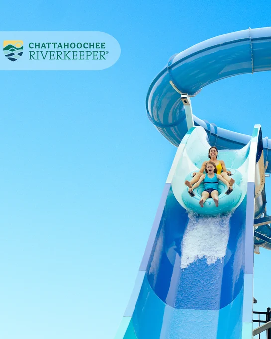 Person rides down a blue water slide with a text and logo overlay for Chattahoochee Riverkeeper.