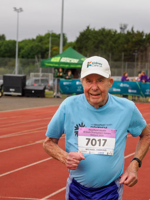 elderly runner in baseball cap running on a athletics race track