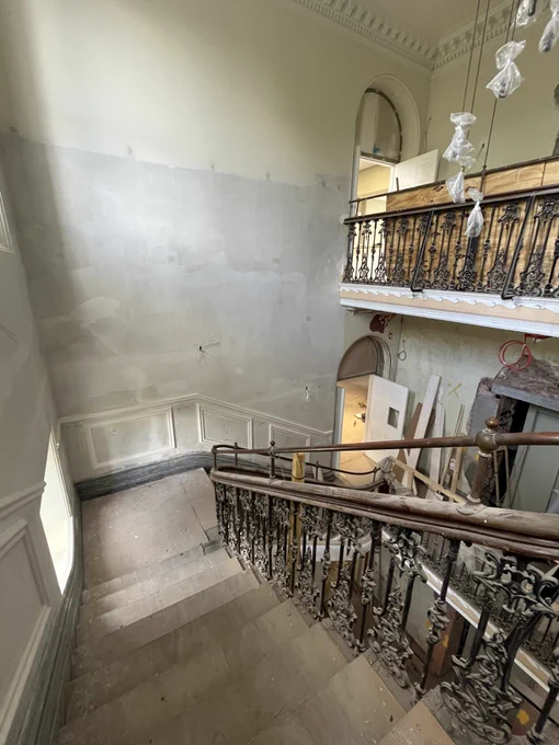 Photo of the staircase and stairs going down inside the mansion