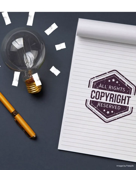 A notepad with "All Rights Copyright Reserved" stamp, a pen, and a light bulb surrounded by small pieces of paper, set against a gray background.