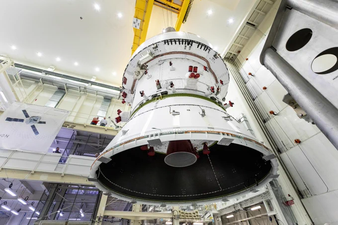 Technicians with NASA and Lockheed Martin operate a 30-ton crane to move NASA’s Artemis II Orion spacecraft out of the Final Assembly and System Testing cell inside the Neil Armstrong Operations and Checkout Building at NASA Kennedy on Feb. 22, 2025. The move prepares for the upcoming installation of four solar array wings and spacecraft adapter jettison fairings. The perspective of the image is from below the Orion spacecraft looking up. Credit: NASA/Cory S. Huston