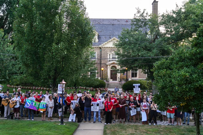 More than a hundred strikers and supporters line up for a photo between the trees outside Post-Gazette publisher John Block's house in Shadyside on Tuesday. University of Pittsburgh Chancellor Joan Gabel's home is visible in the background.