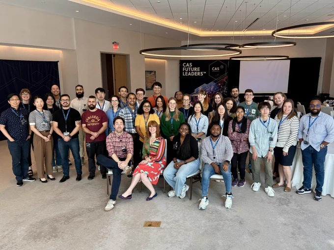 A group of early-career scientists posing with three workshop facilitators sitting in chairs