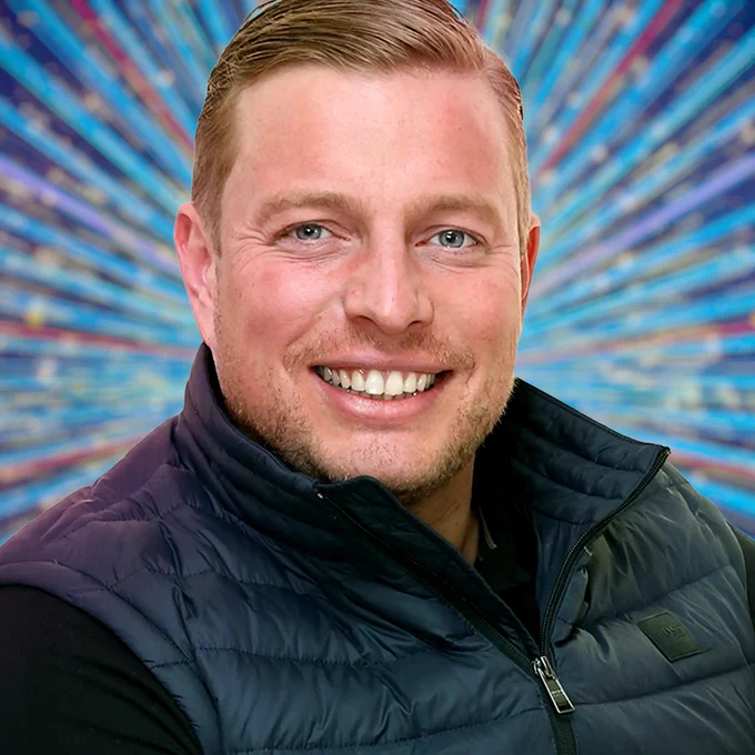 A head and shoulders shot of Thomas Skinner smiling to camera in a dark top and body warmer, set against a glittering blue background.