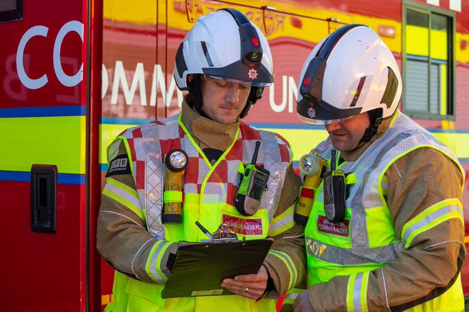 Two firefighters in front of a Command Unit