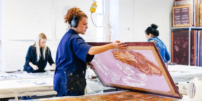 Artists working on prints in a well-lit studio.