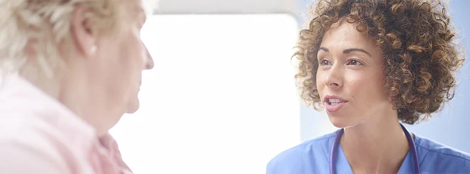 Healthcare professional listening to a patient during a consultation.