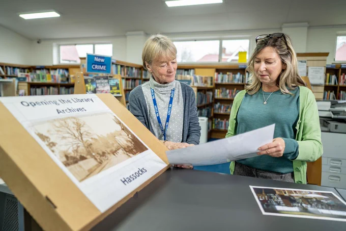 Staff at Hassocks Library looking at the Opening the Archives box.