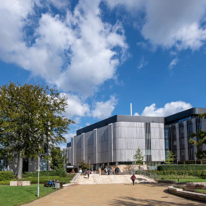 University of Southampton Life Sciences building with a modern facade, a wide pathway lined with greenery, and people walking near the entrance