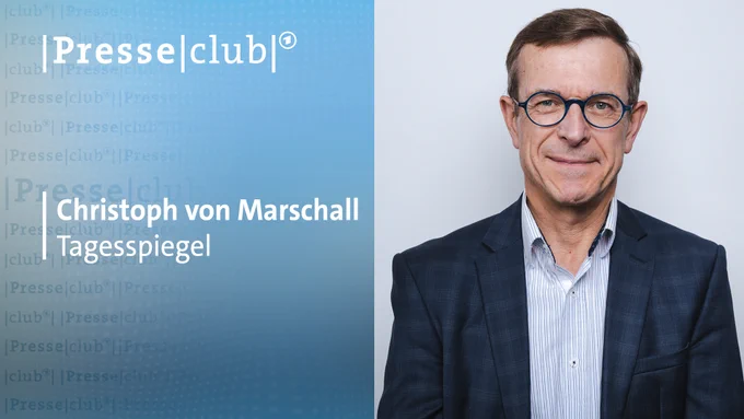 ein Mann mit Brille und einem Anzug