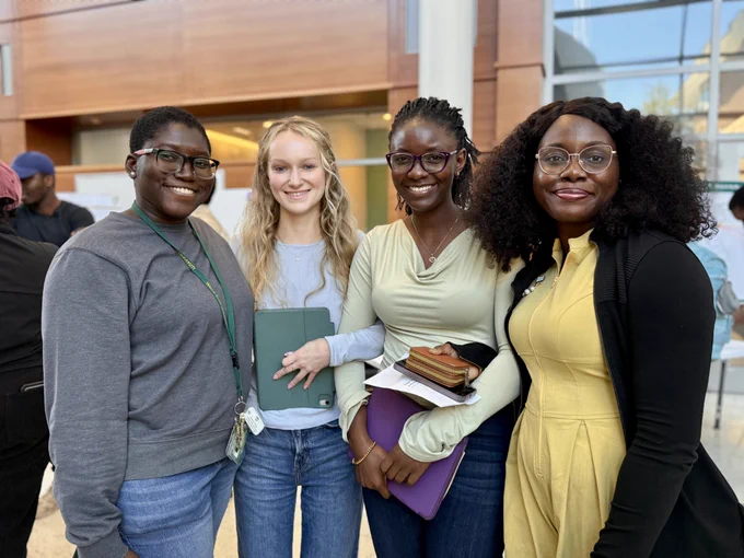 4 people smiling at an event