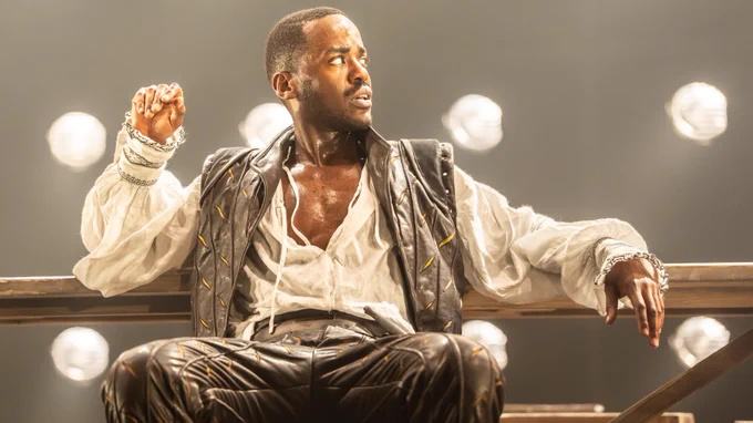 Ncuti Gatwa, sat back and reclining, sweaty with an open shirt