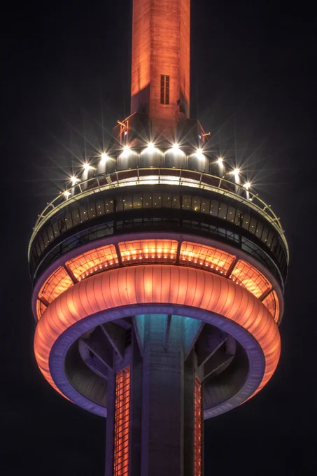 Closeup of the #CNTower at night lit orange/ Gros plan de la #TourCN illuminée en orange la nuit. 